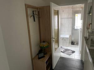 ein Bad mit einer Tür, die sich zu einem Badezimmer mit einem Waschbecken öffnet in der Unterkunft Wohnen Nähe Nordpark in Mönchengladbach