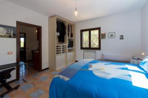 una camera con letto blu e televisore di Suite cucinino, bagno, ingresso indipendente in" Villa VìVì" a Siniscola