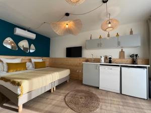 1 dormitorio con 1 cama grande y cocina en Hôtel Café Miramar en Le Grau-du-Roi