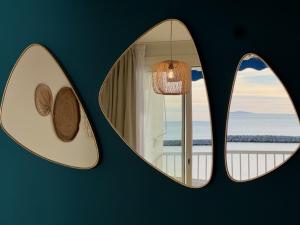 a room with two windows with a view of the ocean at Hôtel Café Miramar in Le Grau-du-Roi