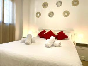 - un lit blanc avec des oreillers rouges et blancs dans l'établissement La Puerta de la Axerquía, à Cordoue