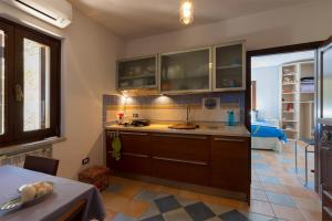 una cucina con armadi marroni e un tavolo in una stanza di Suite cucinino, bagno, ingresso indipendente in" Villa VìVì" a Siniscola