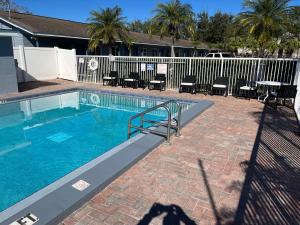 a swimming pool with chairs and a fence at Brandon Motor Lodge in Brandon