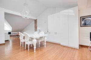 a white dining room with a white table and chairs at Divon Luxury Apartments by Wawel Castle in Krakow