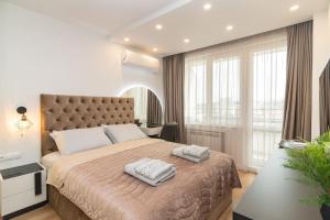 - une chambre avec un grand lit et 2 serviettes dans l'établissement Gran Capital Top Central Apartment, à Sofia