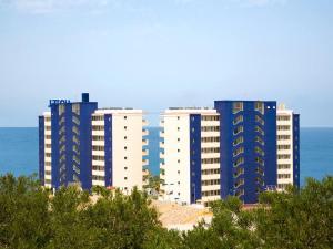 tres edificios azules y blancos frente al océano en Hotel Playas de Torrevieja, en Torrevieja