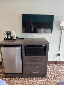 a entertainment center with a tv and a microwave at Brandon Motor Lodge in Brandon