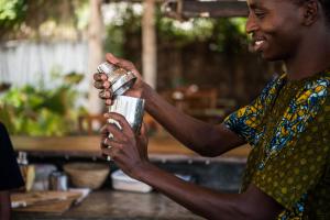 Un homme tient une tasse dans les mains dans l'établissement Kupaga Villas Boutique Hotel - Adults Only, à Jambiani