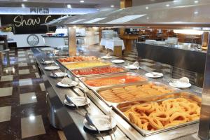 una línea de buffet con muchos tipos diferentes de comida en Hotel Poseidon Playa, en Benidorm