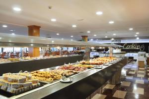 una línea de buffet con muchos tipos diferentes de comida en Hotel Poseidon Playa, en Benidorm