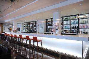a bar with a row of bar stools at Hotel Poseidon Playa in Benidorm