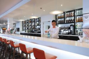 a man standing behind a bar in a restaurant at Hotel Poseidon Playa in Benidorm