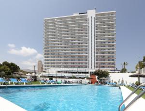 a hotel with a swimming pool in front of a building at Hotel Poseidon Playa in Benidorm