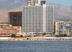 a group of people on a beach with buildings at Hotel Poseidon Playa in Benidorm