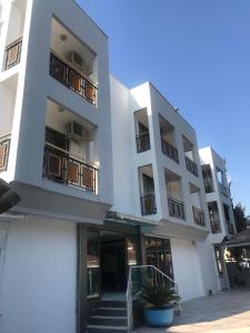 a large white building with stairs in front of it at Kahraman Hotel in Side