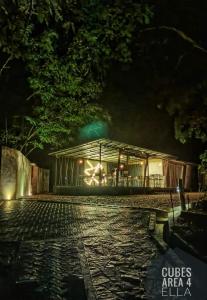 a building at night with lights on a cobblestone street at Area 4 eco cubes in Ella