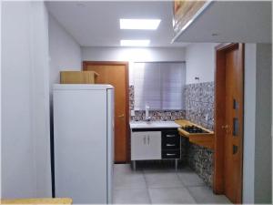 cocina con nevera blanca y fregadero en Loft Rústico - Curitiba, en Curitiba