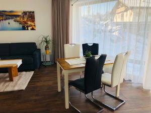 sala de estar con mesa, sillas y sofá en Ferienwohnung Steiner, en Tulfes