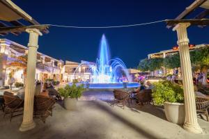 a fountain in the middle of a city at night at Tigaki Mall Hostel in Tigaki