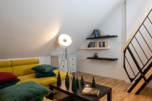 uma sala de estar com um sofá amarelo e uma mesa em Apartments Gozdni Raj Rogla em Oplotnica