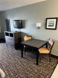 a hotel room with a table and chairs and a tv at Brandon Motor Lodge in Brandon