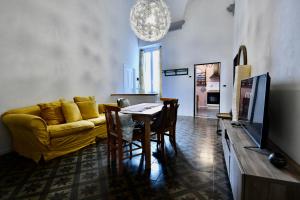 a living room with a yellow couch and a table at Hotel Villa Maria & Apartment in Varazze