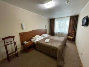 ein Hotelzimmer mit einem Bett und einem Stuhl in der Unterkunft Отель Турист in Iwanowo