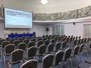 une salle de conférence avec des chaises et un écran de projection dans l'établissement Отель Турист, à Ivanovo