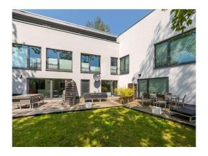 a large white building with a patio and a yard at Suite-Meerblick-Juliusruh in Juliusruh