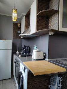 a kitchen with a wooden cutting board on a counter at Mladost 1 Apartment near the metro in Sofia