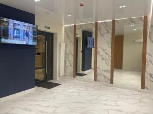 a lobby with mirrors and a tv on a wall at Optima Collection Nizhyn in Nizhyn