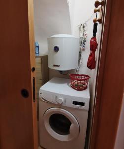 a washing machine with a bucket on top of it at Hope's corner apartment in Terracina +4 photos