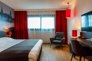 ein Hotelzimmer mit einem Bett, einem Schreibtisch und einem Stuhl in der Unterkunft Bastion Hotel Groningen in Groningen