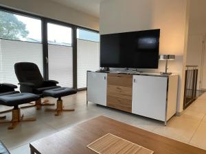a living room with two chairs and a flat screen tv at Suite-Meerblick-Juliusruh in Juliusruh
