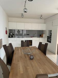 a dining room table with chairs and a kitchen at Suite-Meerblick-Juliusruh in Juliusruh