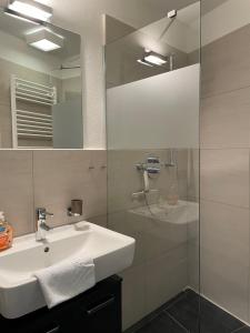 a bathroom with a sink and a glass shower at Suite-Meerblick-Juliusruh in Juliusruh +37 photos