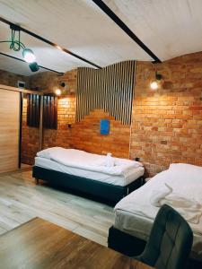 Un dormitorio con dos camas y una pared de ladrillo. en Pokoje Jola, en Drawsko Pomorskie