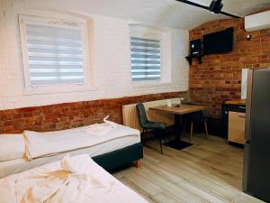 a room with two beds and a table and a kitchen at Pokoje Jola in Drawsko Pomorskie