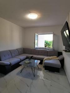 sala de estar con sofá y TV en Apartment Sea, en Supetarska Draga