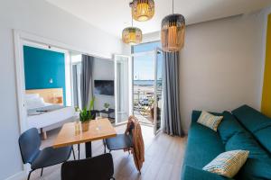 a living room with a green couch and a table at Hôtel Café Miramar in Le Grau-du-Roi