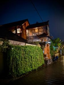 a building with a bush in front of it at night at Sunshine Vintage House in Ubud