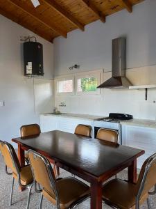 a kitchen with a wooden table and chairs in it at Casa de campo en Tomás Jofré in Tomás Jofré