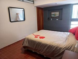 1 dormitorio con 1 cama con espejo en la pared en Departamento de Sil en Godoy Cruz