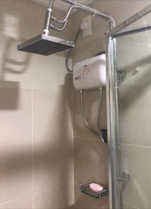 a shower in a bathroom with a shower head at Staycation in Manila