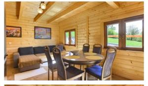 a dining room with a table and chairs and a couch at Domek w Świątkowej in Krempna