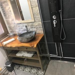a bathroom with a stone sink and a shower at Ambiance petit chalet in La Salle Les Alpes