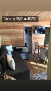 ein Wohnzimmer mit einem Sofa und einem Tisch in der Unterkunft Ambiance petit chalet in La Salle Les Alpes