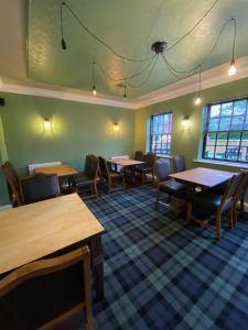a dining room with tables and chairs and windows at The Redwell Inn in Barnard Castle