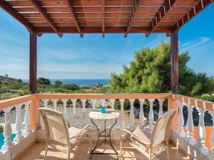 a patio with a table and chairs and the ocean at Villa Pefki in Pefki
