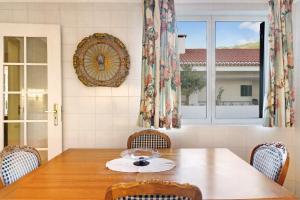 a dining room with a table and a clock on the wall at Bela Sao Tiago 36 in Funchal